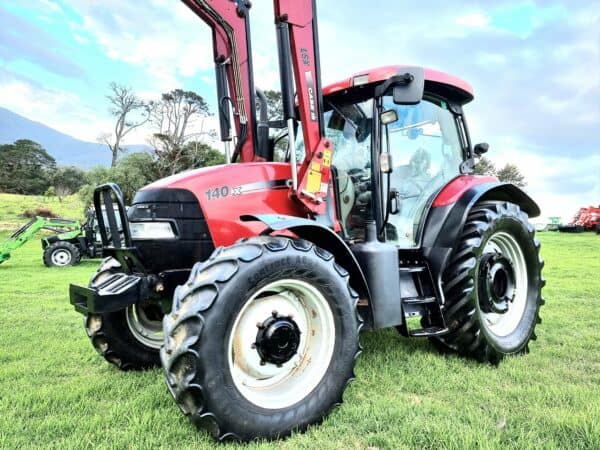 Used red tractor sitting on field in Bega